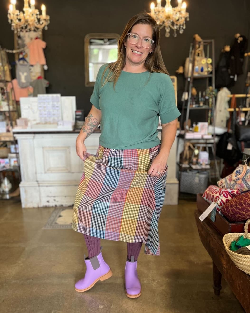 an image of a woman standing in a store wearing a skirt and purple boots