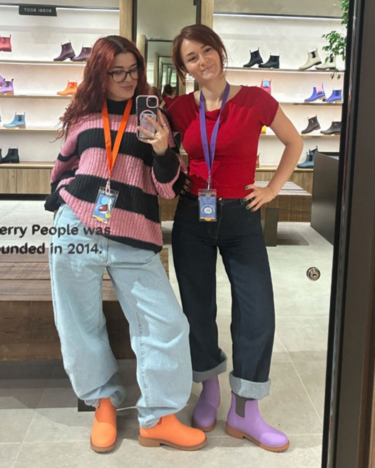 an image of two women standing in front of a mirror in boots