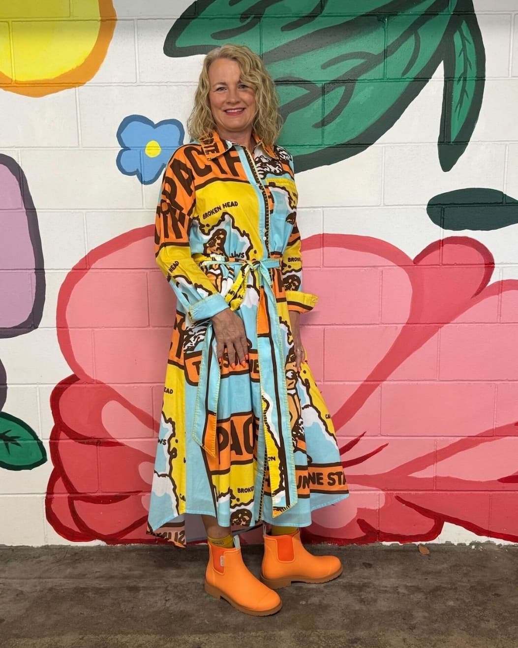 an image of a woman standing in front of a wall with a mural