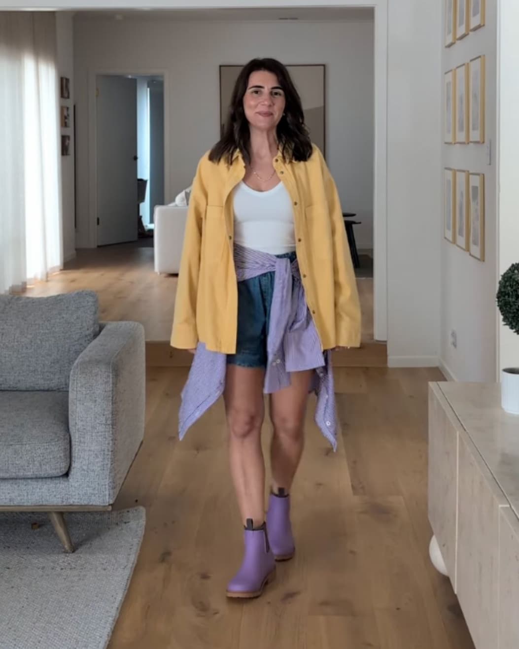 an image of a woman walking down a hallway in a yellow shirt and purple boots