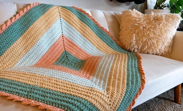  Orange, blue, yellow and white Pique-A-Boo Baby Blanket by Heart Hook Home on couch