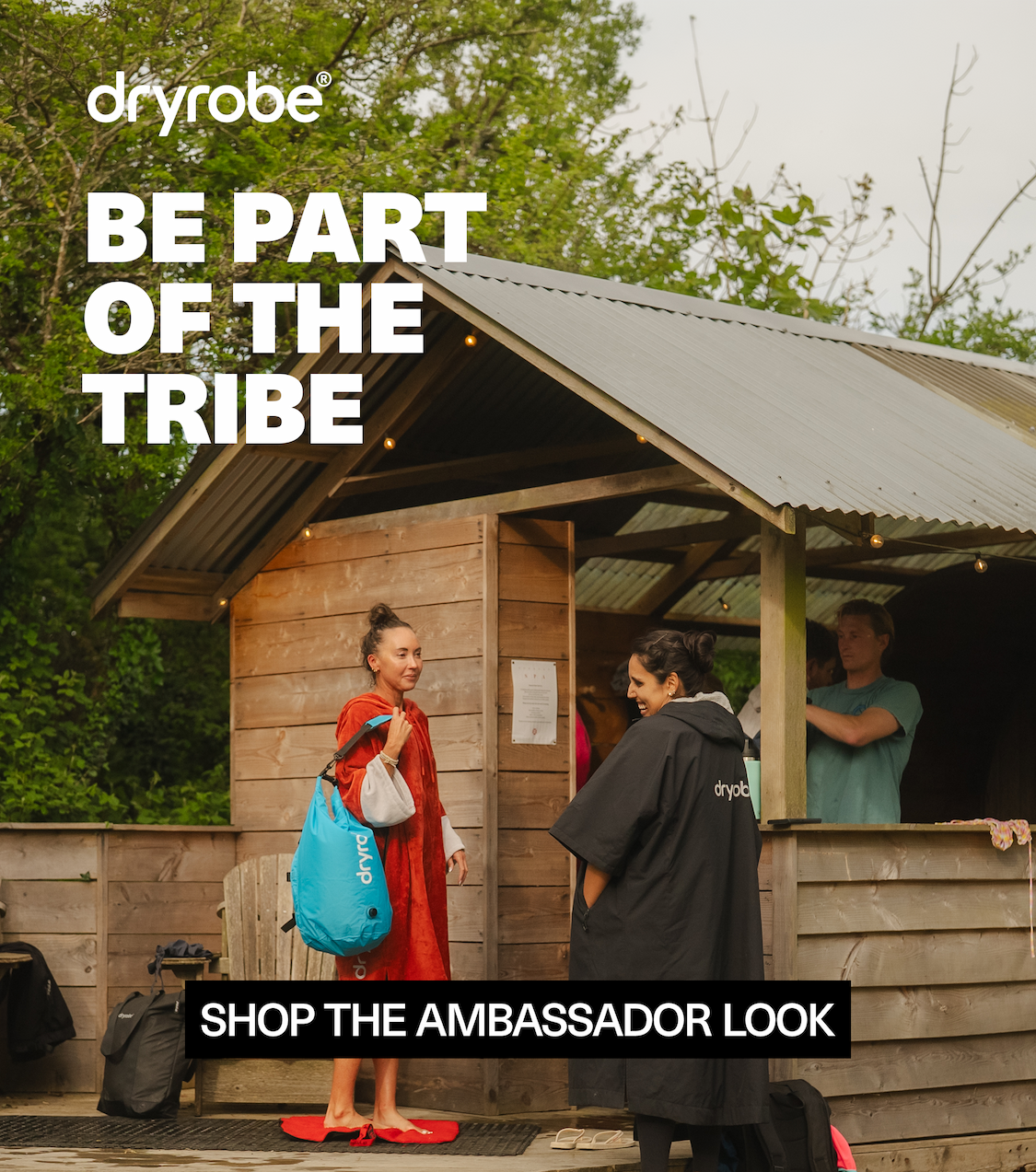 People outside wooden hut with Dryrobe towel robe, Nexus and compression bag
