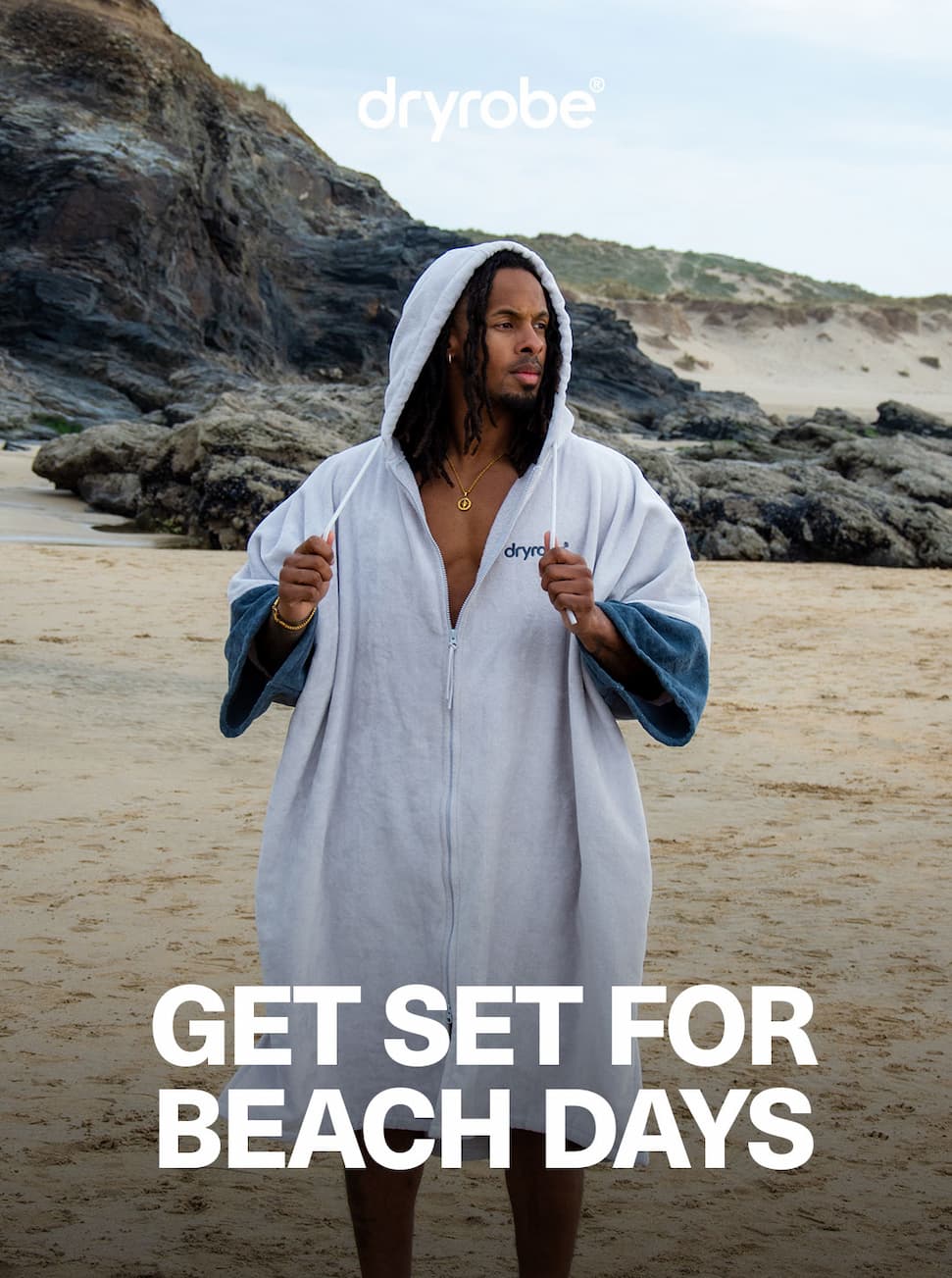 Man standing on the beach while wearing a full-zip towel robe