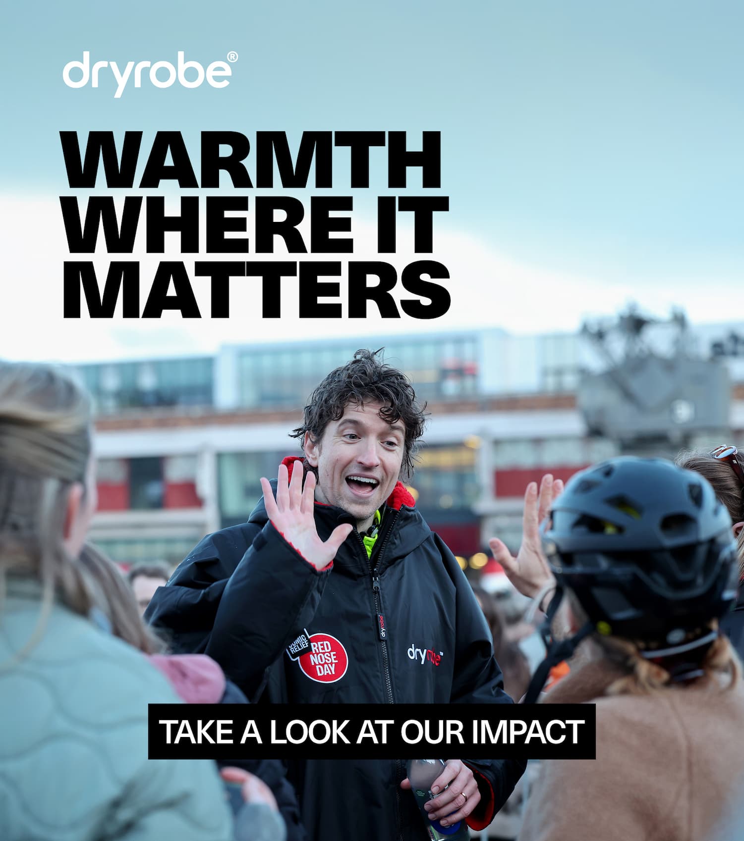 BBC Radio 1 Presenter Greg James wearing a Dryrobe® Advance high fiving a support during his Comic Relief challenge