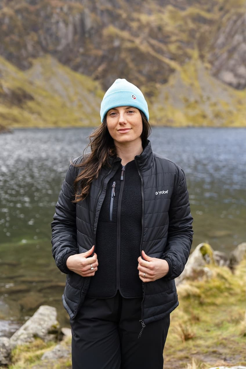 Woman wearing a lightweight jacket with a lake in the background