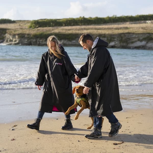 Couple on the beach shoreline with their puppy