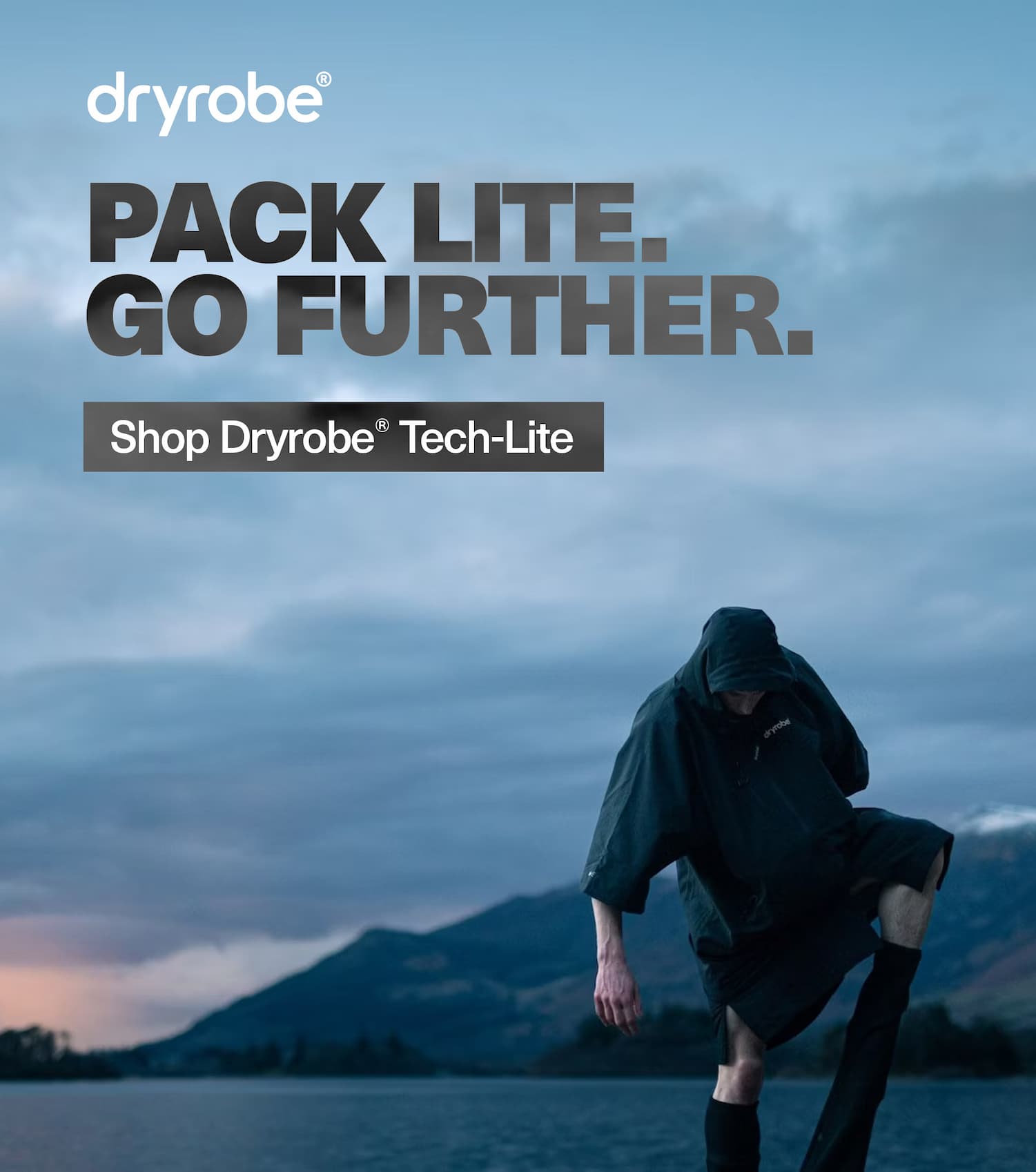 Person wearing a Dryrobe® Lite whilst getting changed by a lake