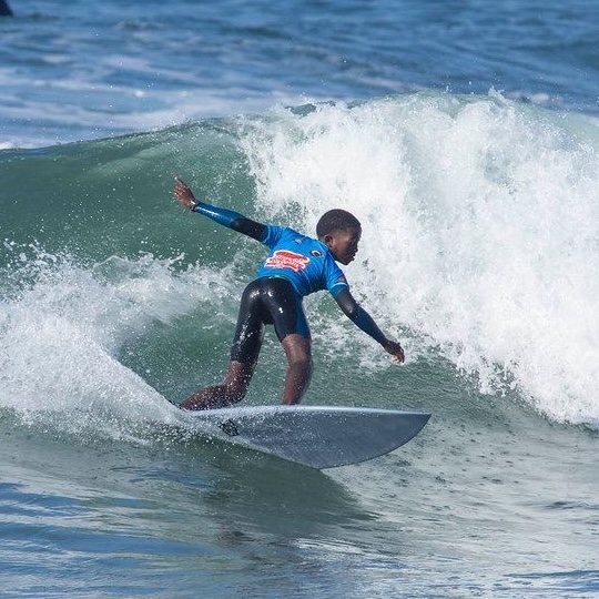 Young boy surfing a wave in the ocean