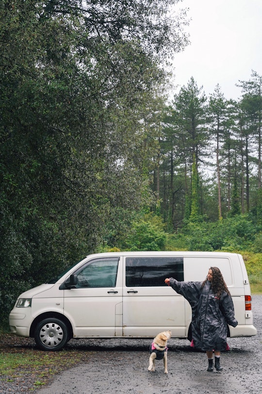 Woman stood beside her van with the dog in the boot