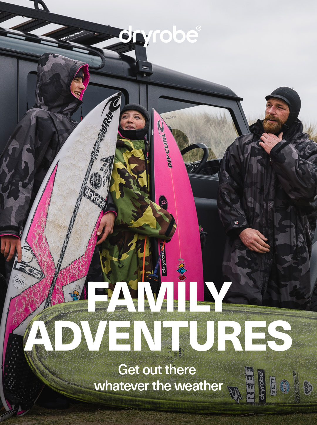 Family in dryrobes and winter gear about to go surfing
