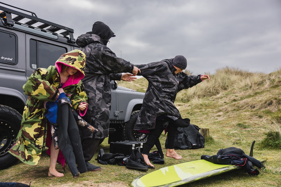 Family having fun and getting changed for a surf on the sand dunes