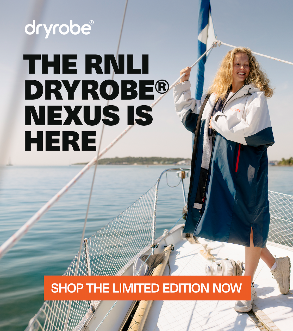 Smiling woman wearing a Limited Edition RNLI Dryrobe® Nexus on a boat