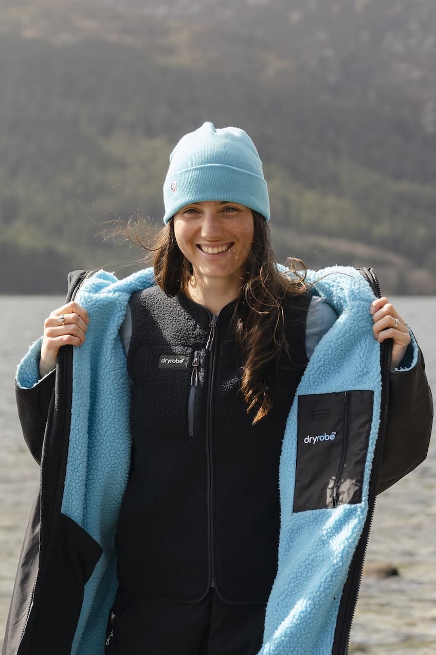 Woman wearing a changing robe with mountains in the background