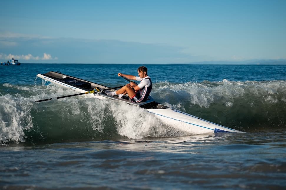 A rower paddling over a wave