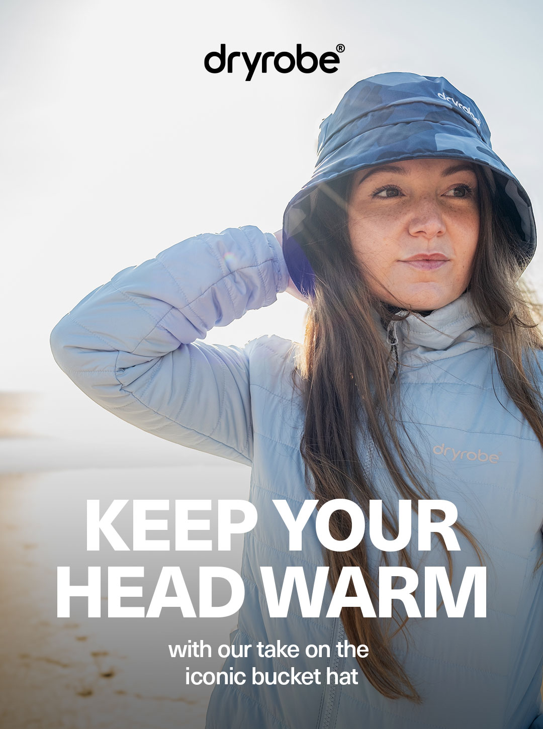 Woman wearing a dryrobe® Mid-Layer and Bucket Hat with the sun directly behind her