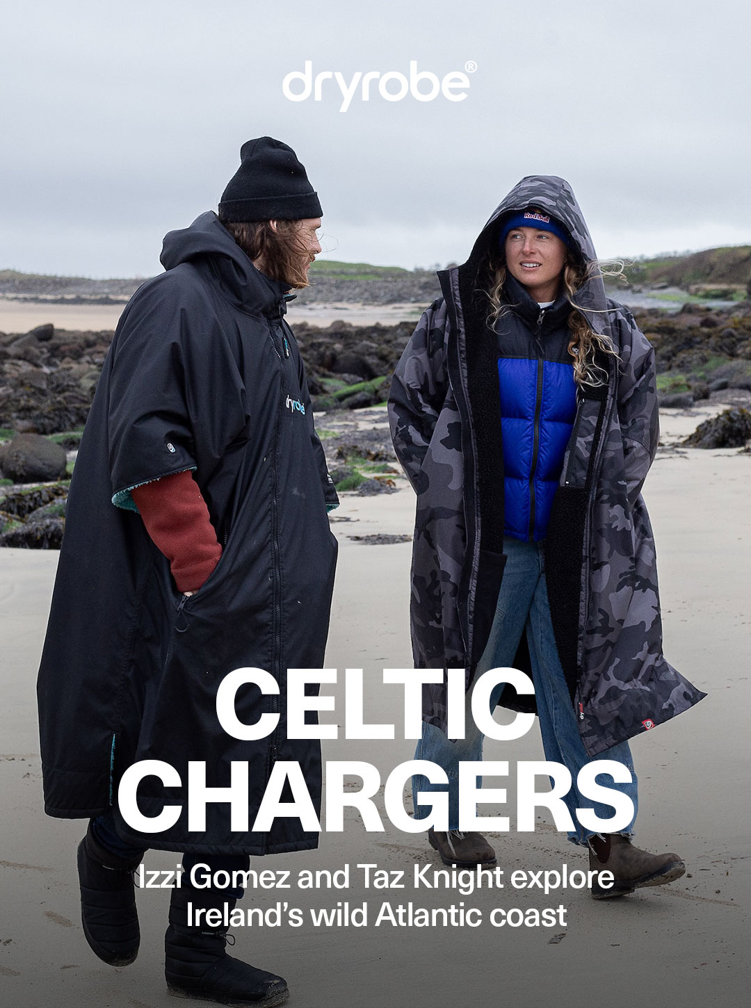 Taz Knight and Izzi Gomez wearing dryrobe® gear in harsh conditions on an Irish beach