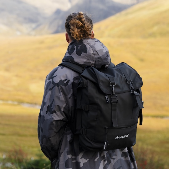 Man wearing a Dryrobe® Compression Backpack while exploring the mountains
