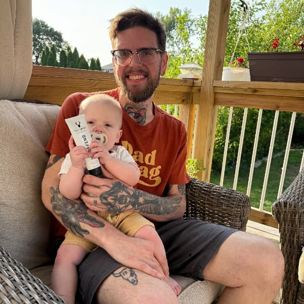Tattooed dad and baby on a sunny deck with Mad Rabbit SPF. Tattooed dad and baby on a sunny deck with Mad Rabbit SPF.