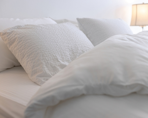 A bed made up in white sheets and comforter