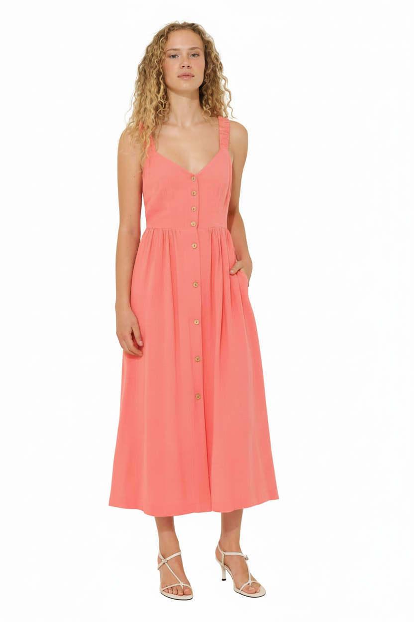 Woman in a coral button-front midi dress with white strappy heels.