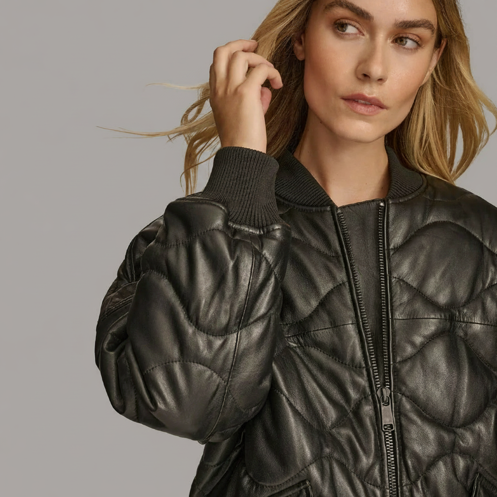 Woman wearing a black quilted leather bomber jacket.