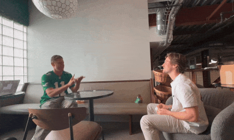 Guy in sports jersey flicks Level 3 Watermelon Kiwi into co-workers mouth