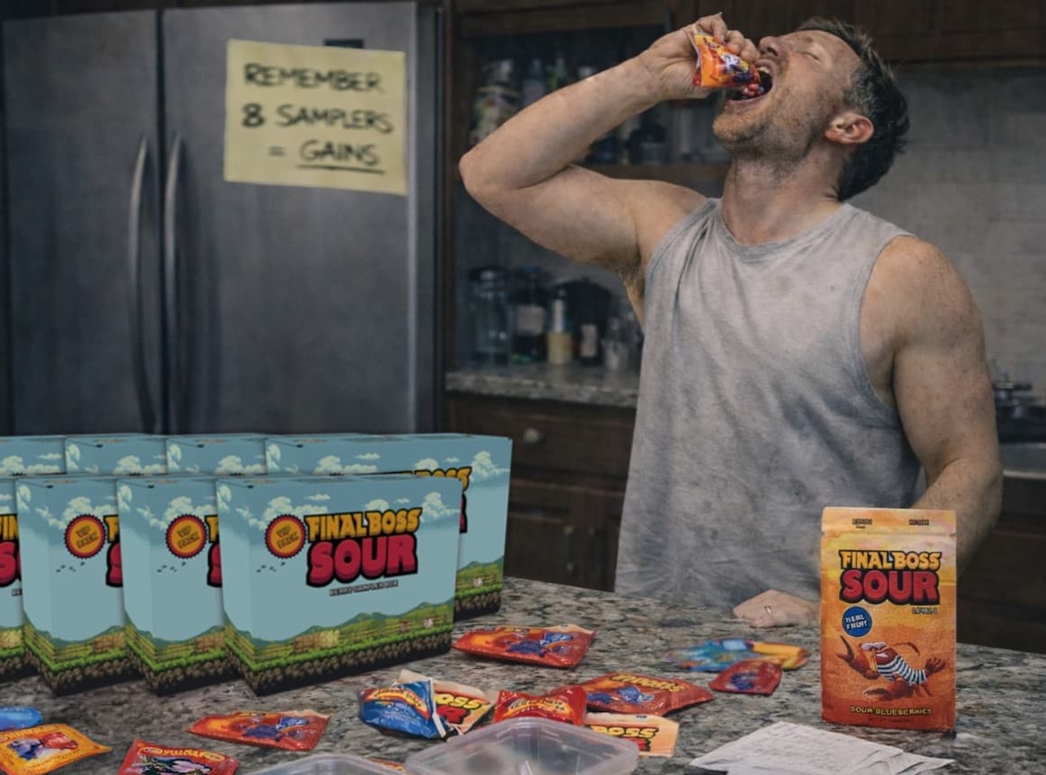 Guy pours bag of Final Boss Sour into mouth while wearing gym shirt