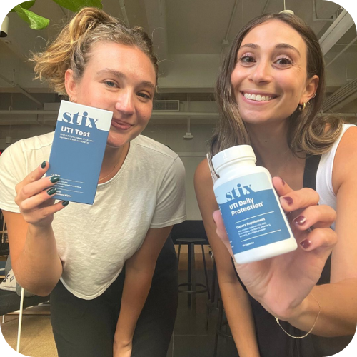 Jamie and Amanda holding UTI Tests and UTI Daily Protection Supplement