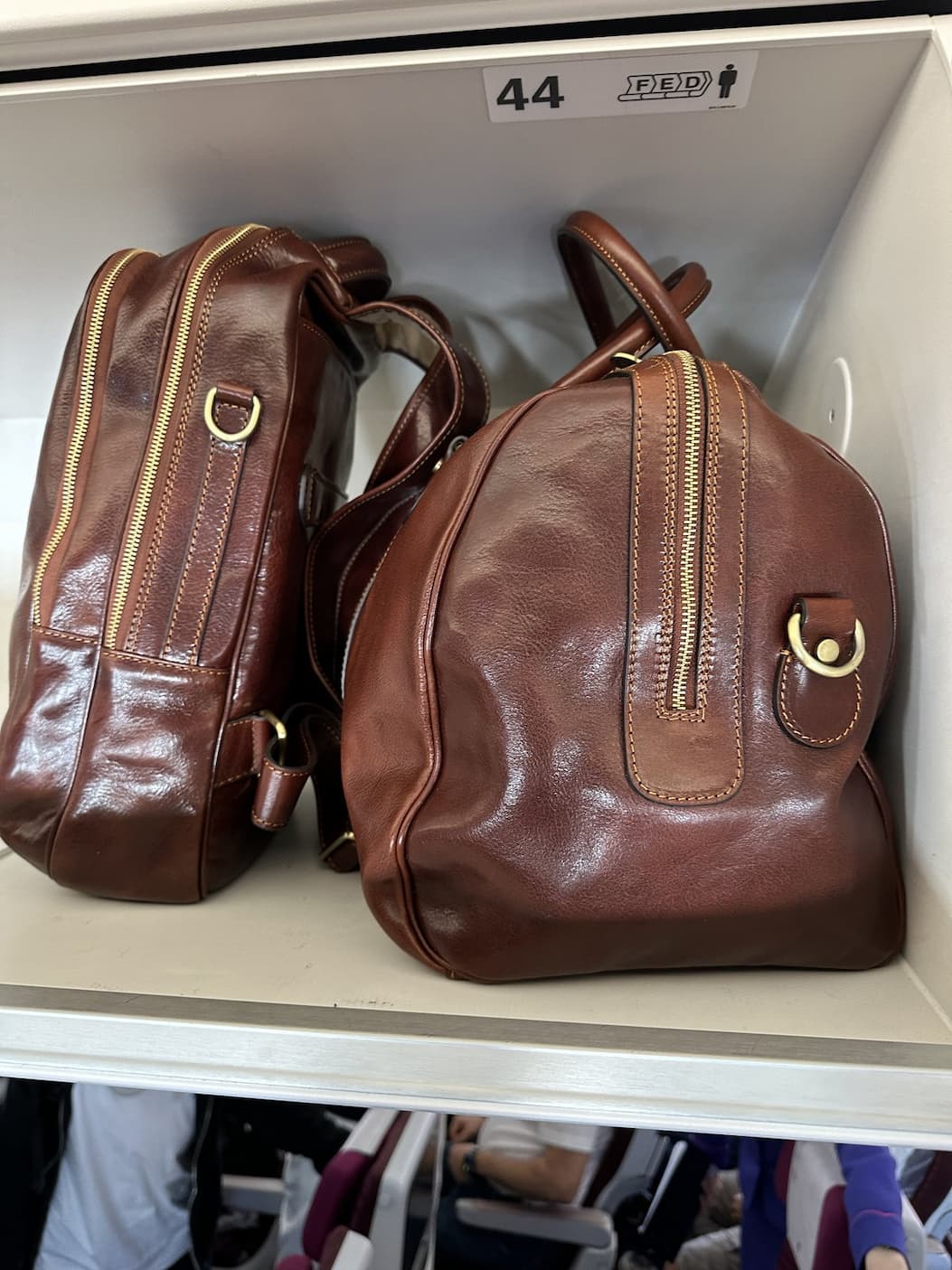 The Beltrami and the Belfast, side by side in the overhead bin.