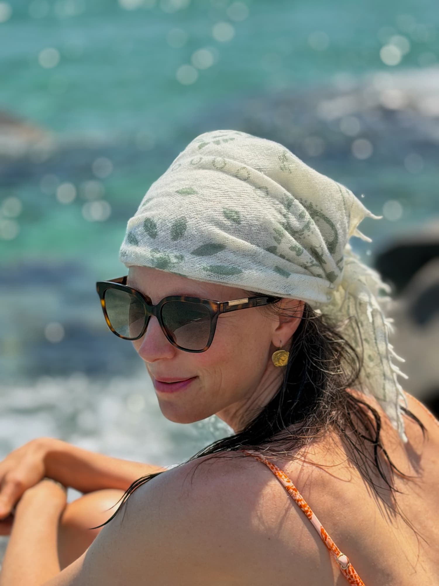 Frau mit Bandana-Tuch Camille mit Paisley-Muster auf dem Kopf am Meer