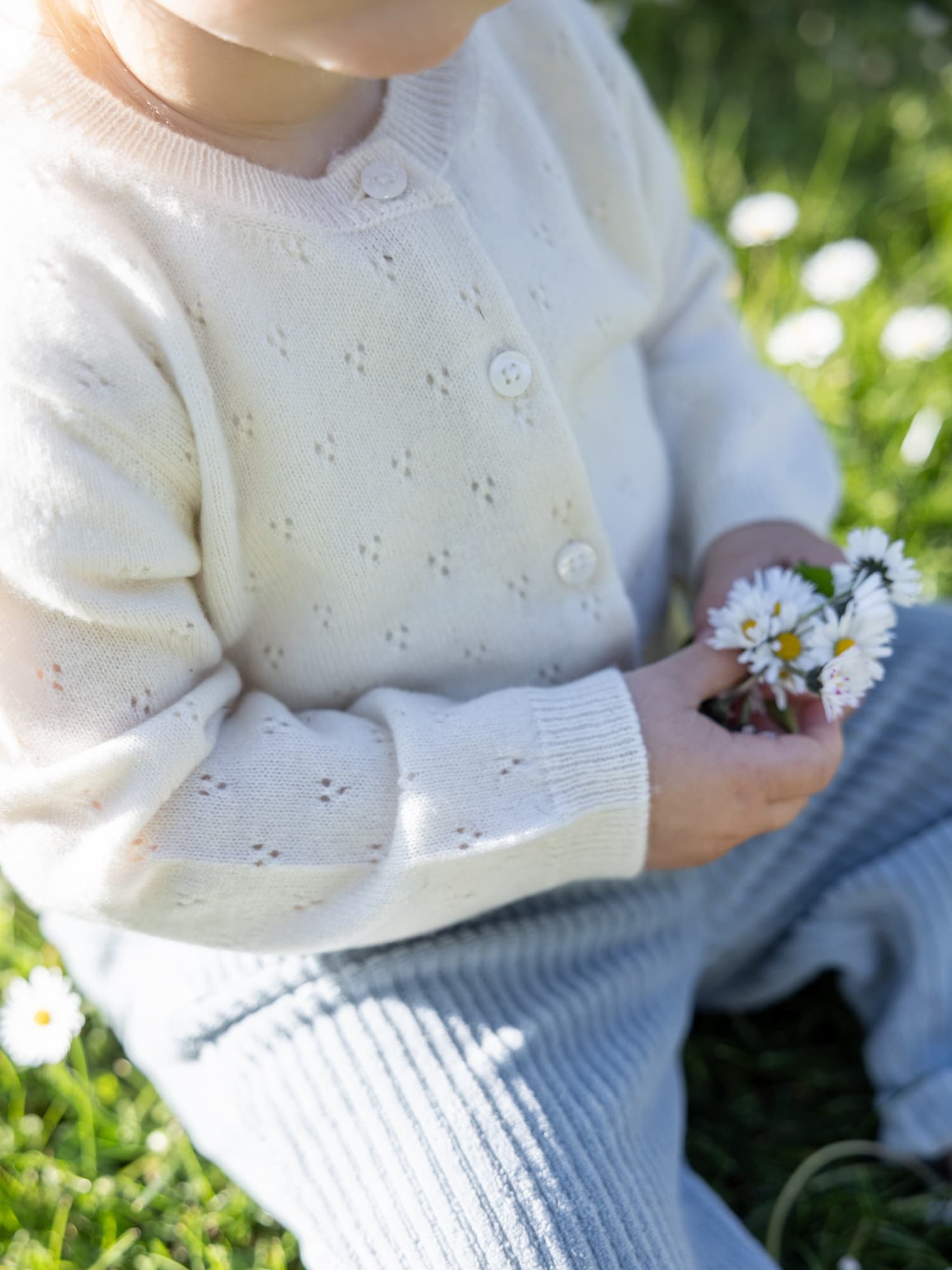 Sitzendes Kind mit Blumenstrauss