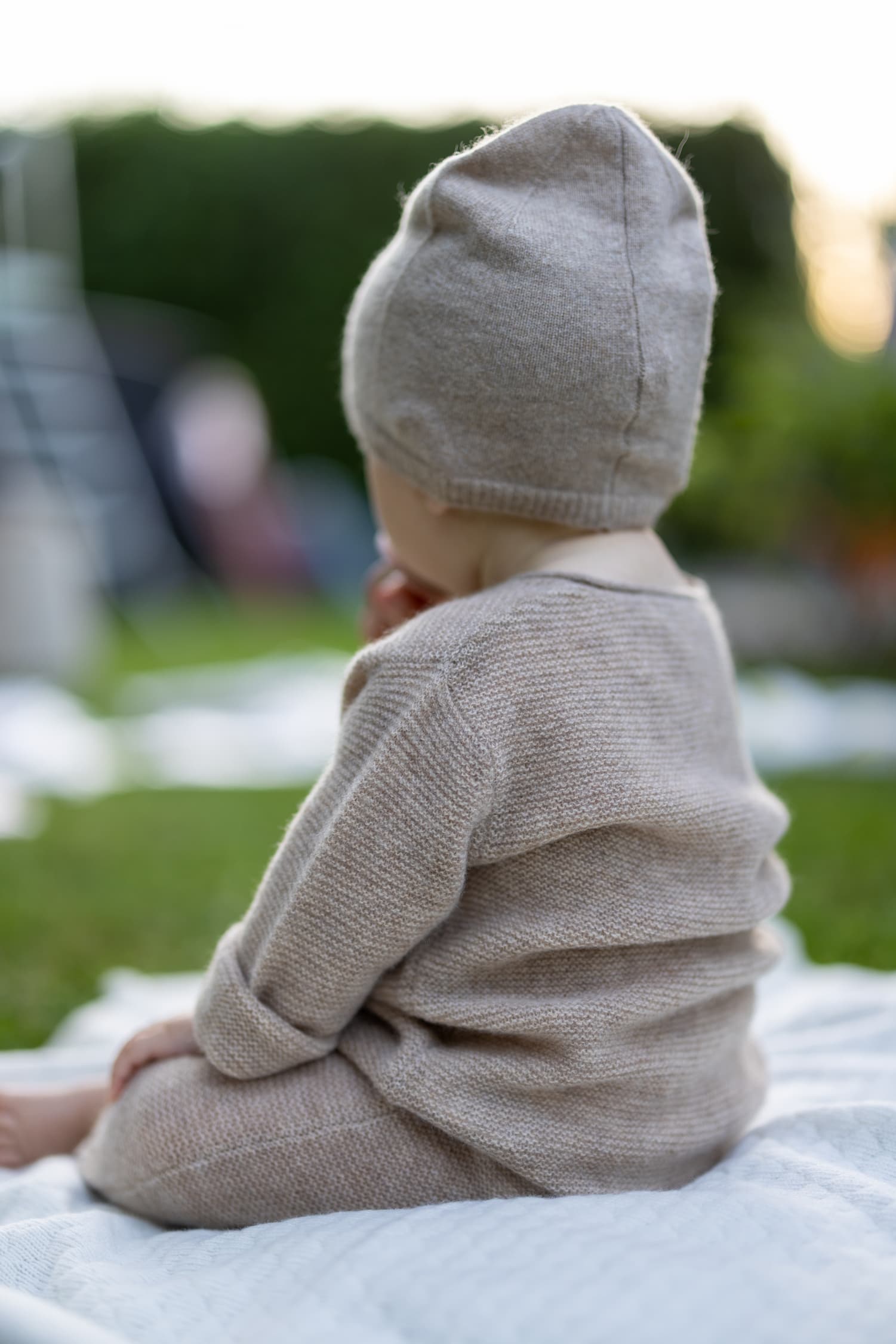 Baby sitzend von hinten in Strampelanzug ANOUK