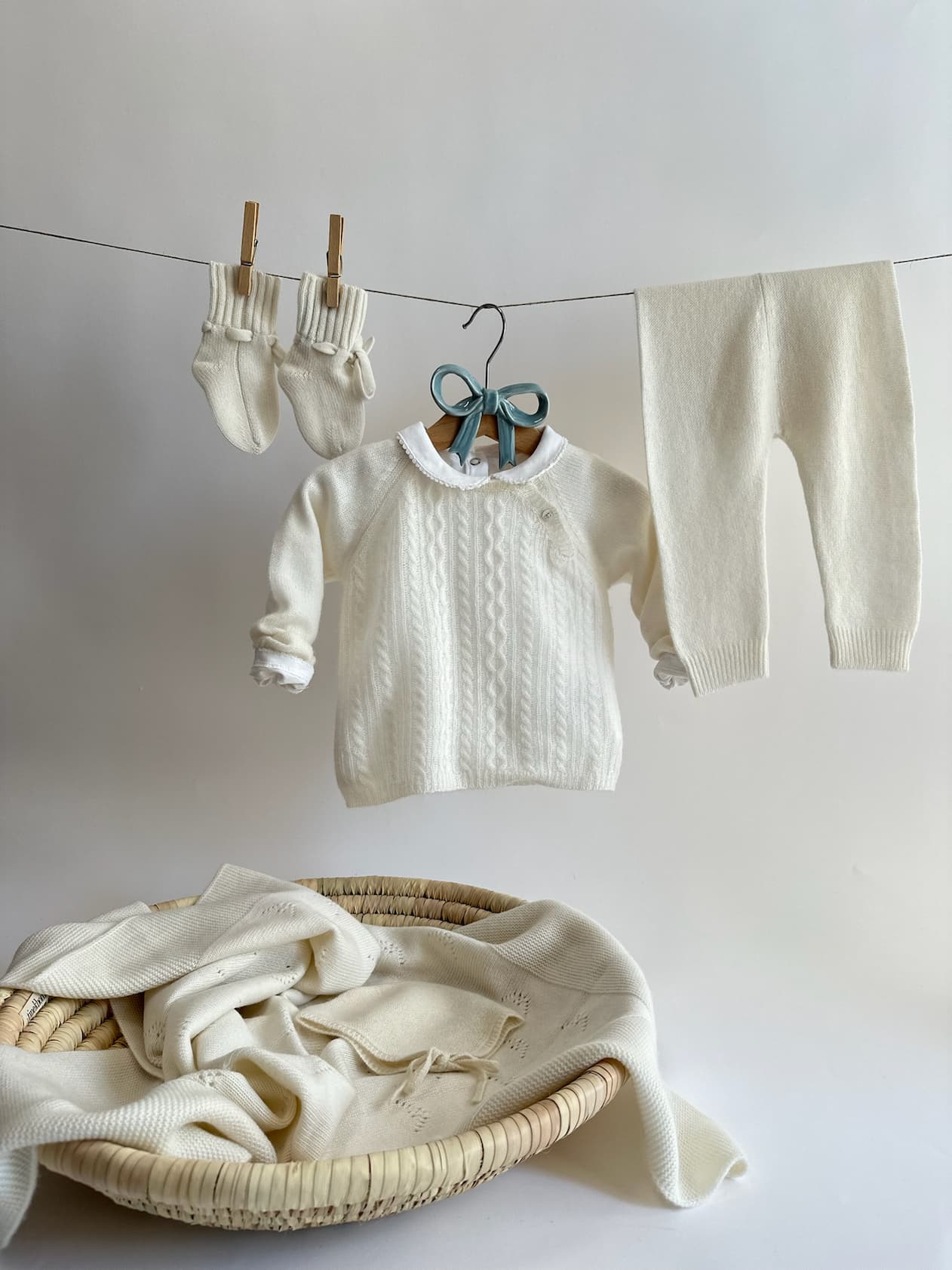 Weisses Kaschmir-Babyset und Söckchen an Wäscheleine