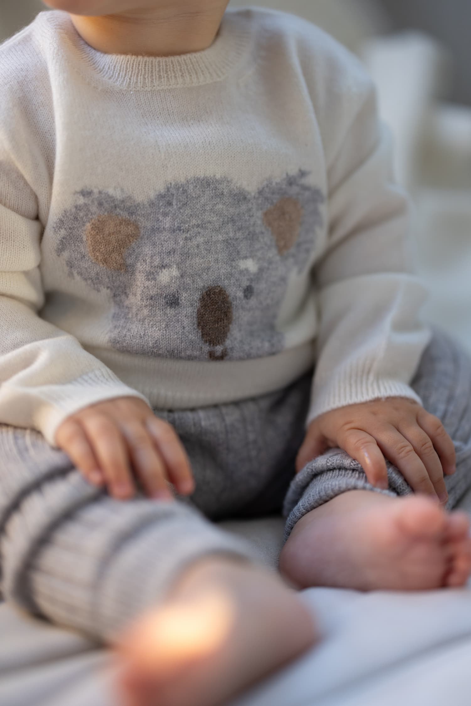 Baby sitzend mit Kaschmir Pullover KOALA und Leggings