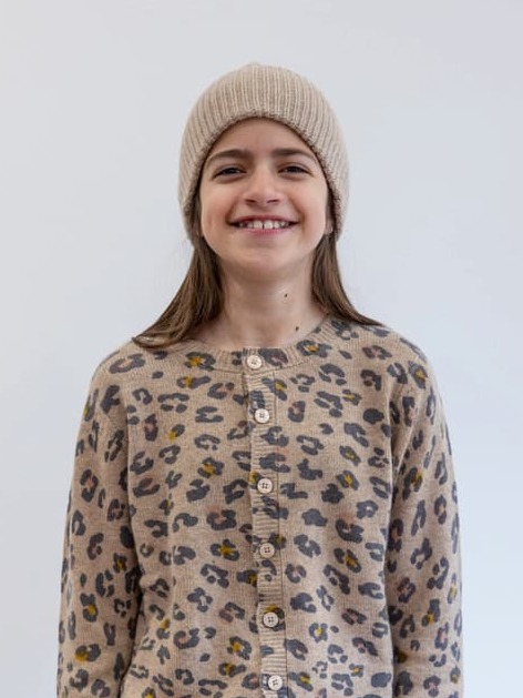 Lachendes Mädchen mit Kaschmir-Cardigan LEO, Hose MARLENE und Mütze CALLISTO