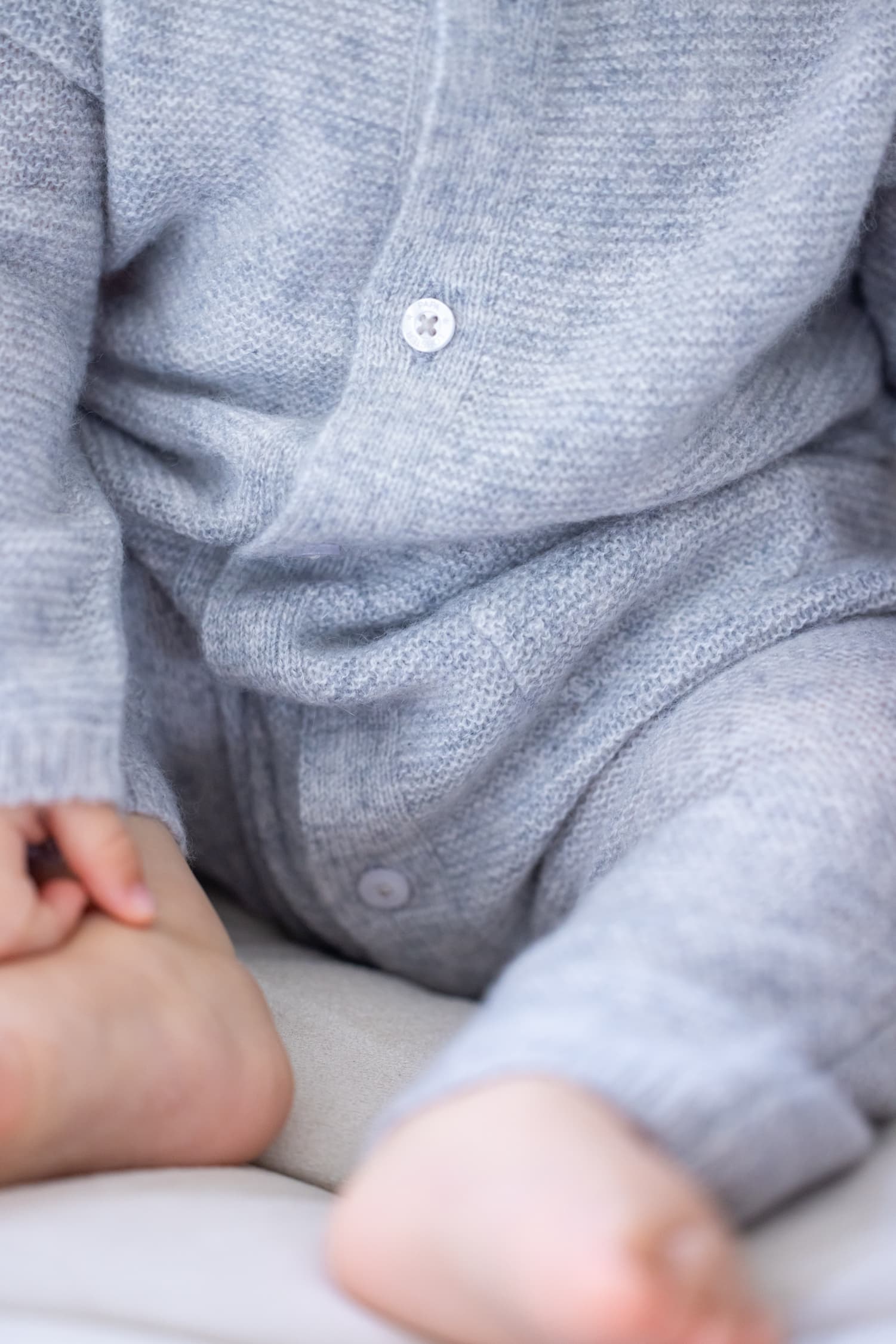 Detailaufnahme Baby sitzend in Strampelanzug ANOUK