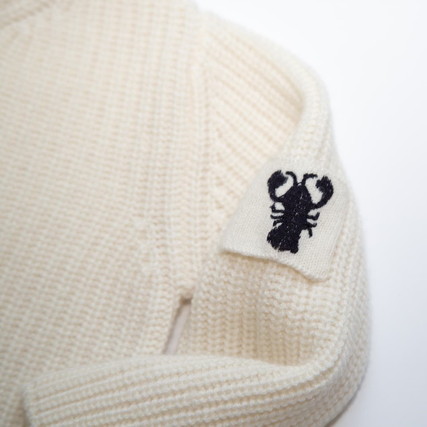 Detailaufnahme von Lobster-Emblem auf Kaschmir-Pullover JENSON