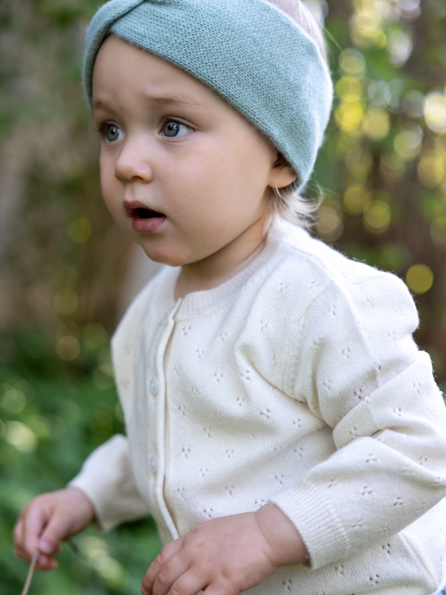 Babymädchen mit Stirnband und Kaschmir-Cardigan