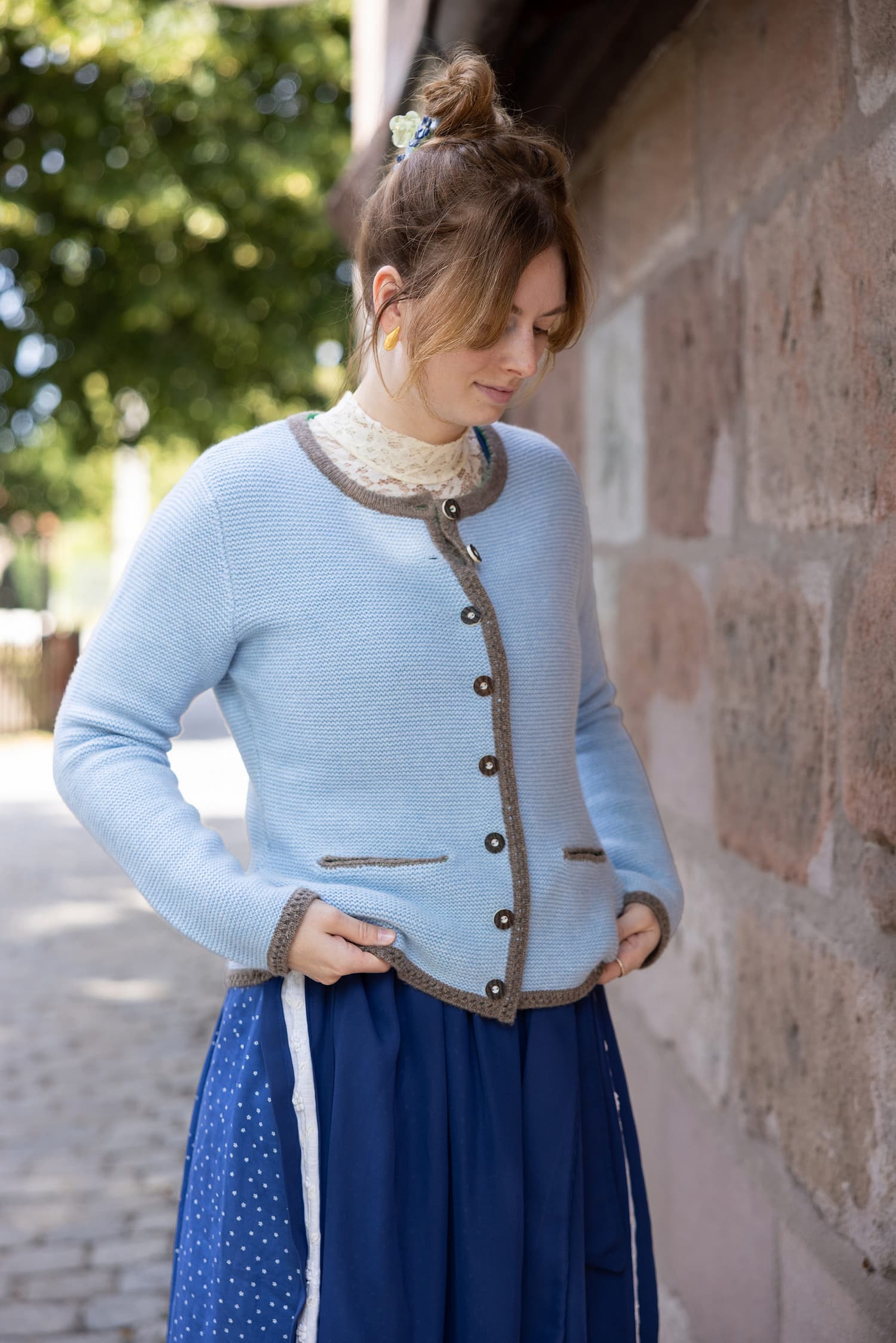 Stehende Frau mit Cardigan LENI in Hellblau und mit Dirndl