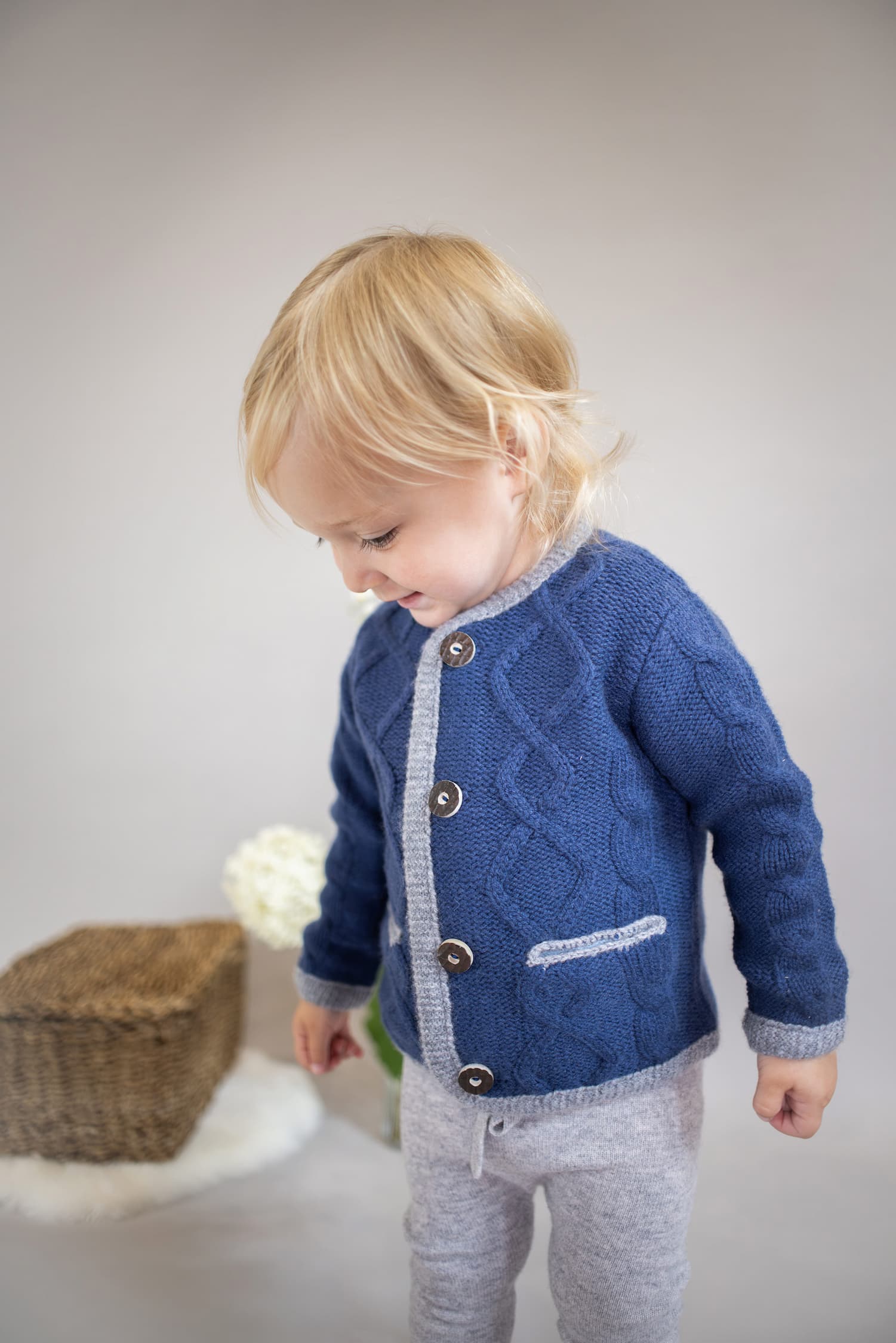 Toddler Mädchen in Kaschmirjacke MAXI schaut auf den Boden.