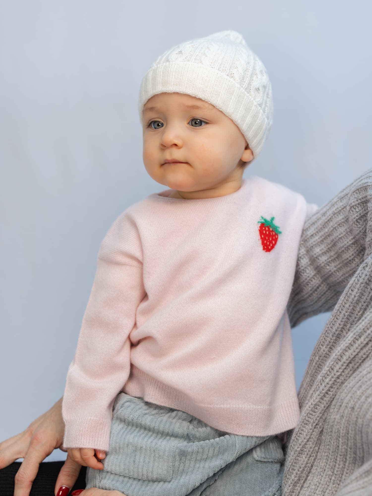 Baby in Pullover mit Erbeer-Intarsie