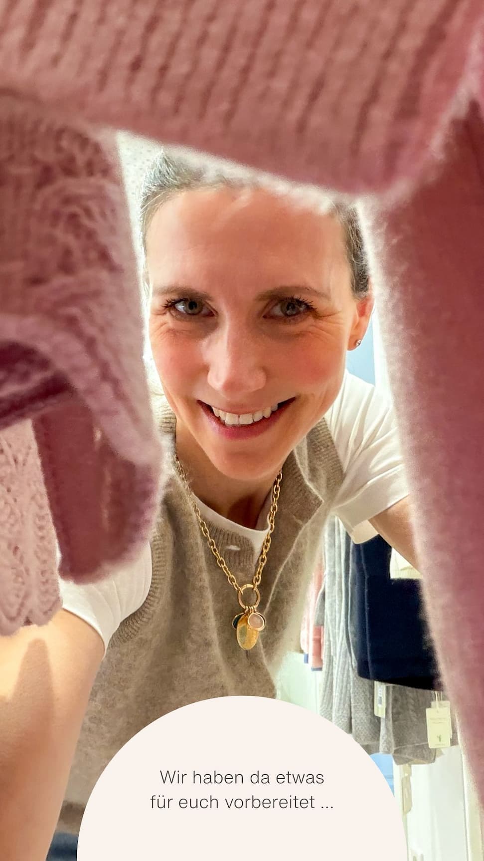 Frau schaut durch Kaschmirteile hindurch in die Kamera Frau schaut durch Kaschmirteile hindurch in die Kamera