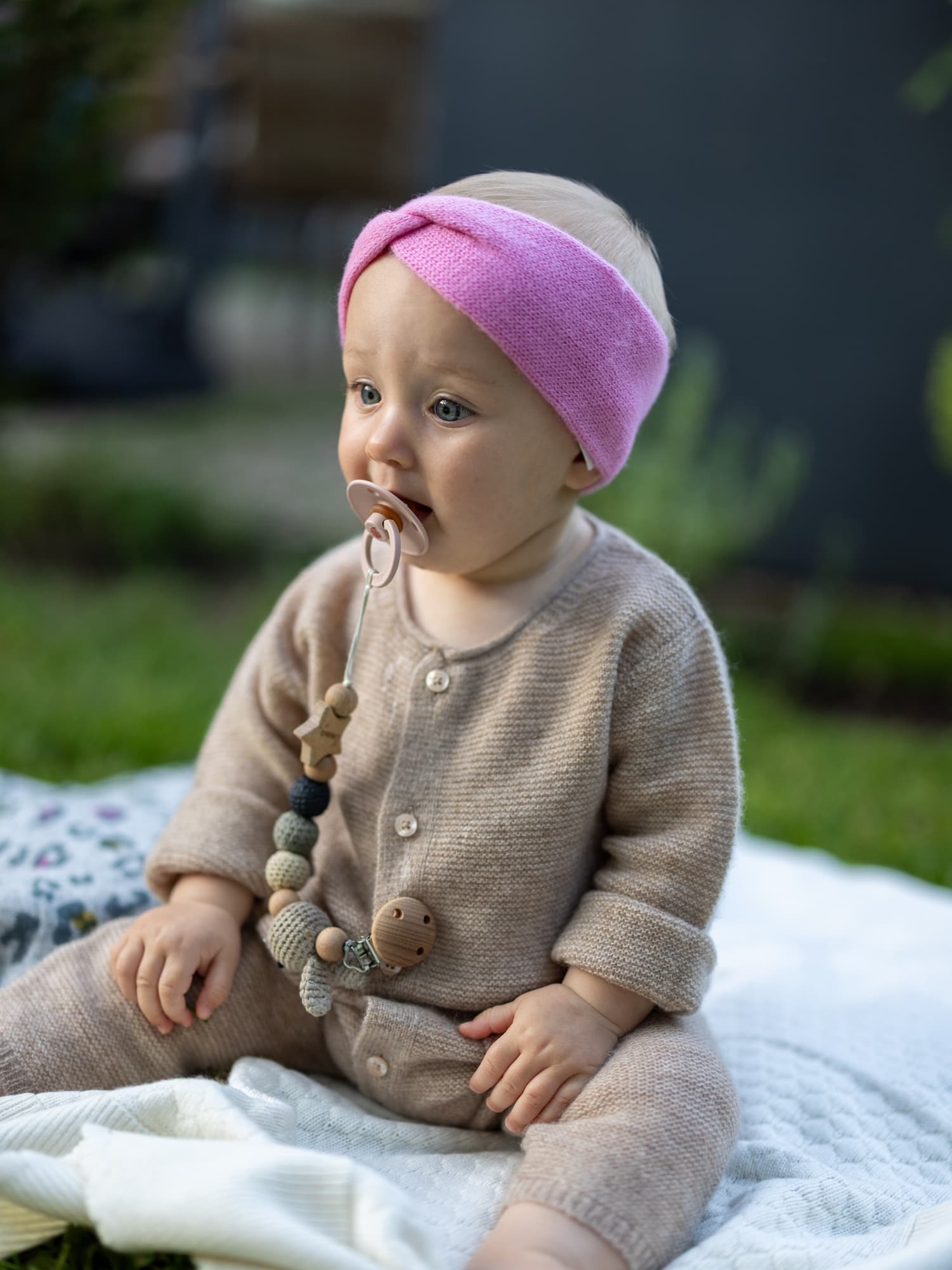 Sitzendes Baby mit Stirnband MAXI in Rosa