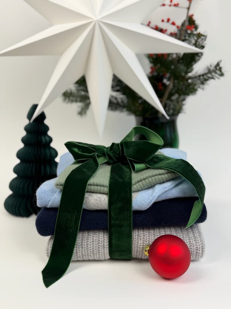 Kaschmirstapel mit Geschenkschleife weihnachtlich dekoriert