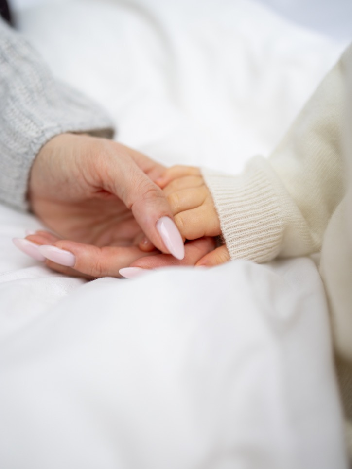 Hand in Hand Detailfoto von Mama- und Babyhänden