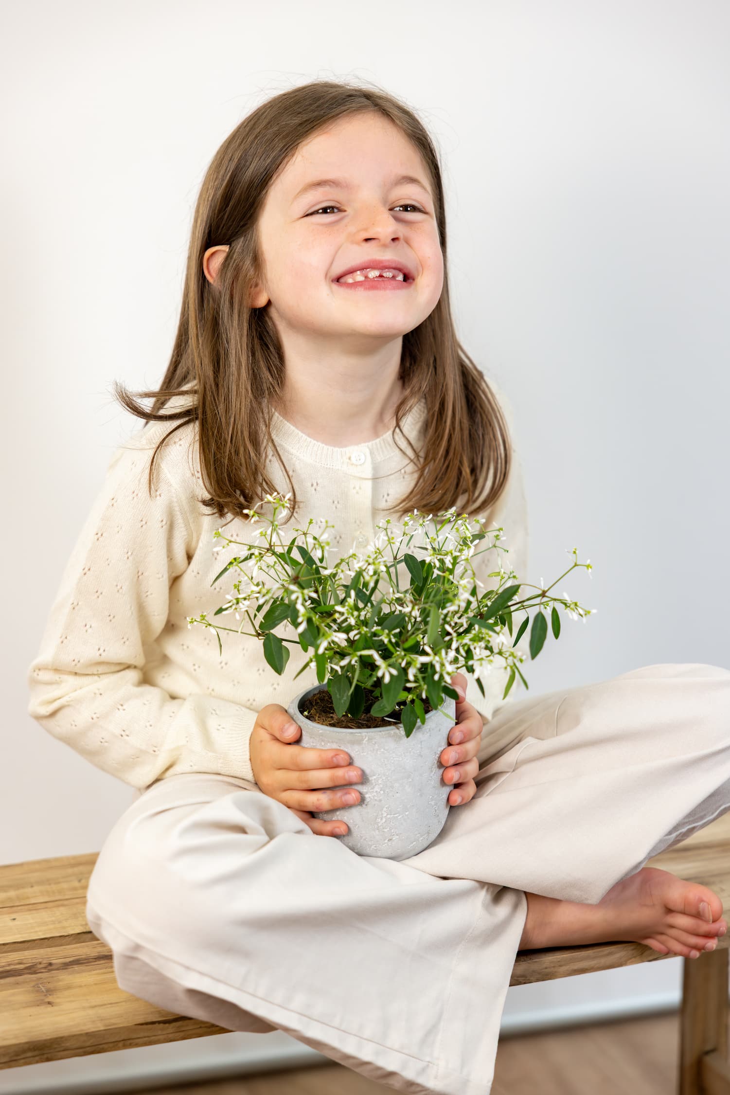 Sitzendes Kind mit Blumentopf