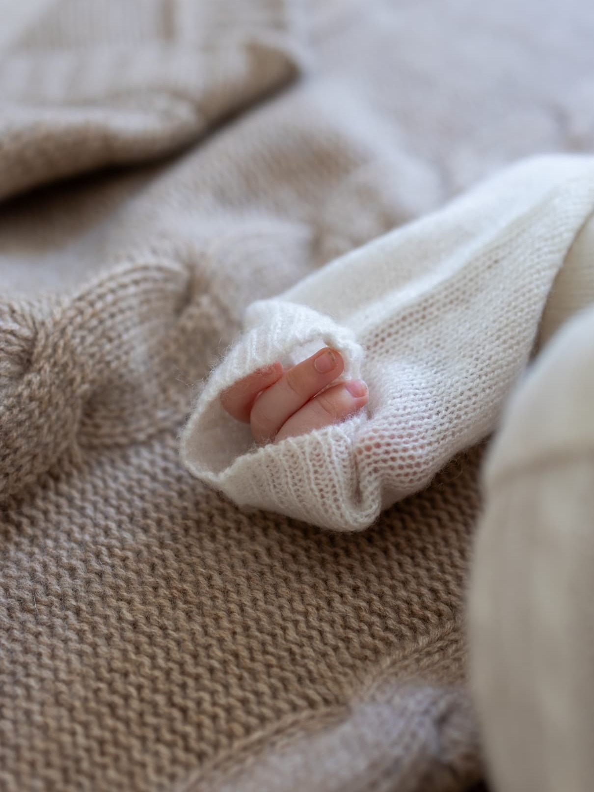 Babyarm und Fäustlein in Baby Set AMARI in Weiss auf Kaschmirdecke JULES in Beige