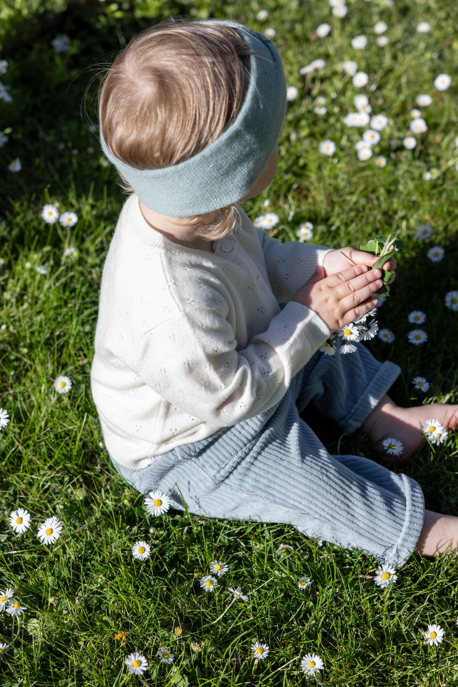Babymädchen sitzend auf Blumenwiese
