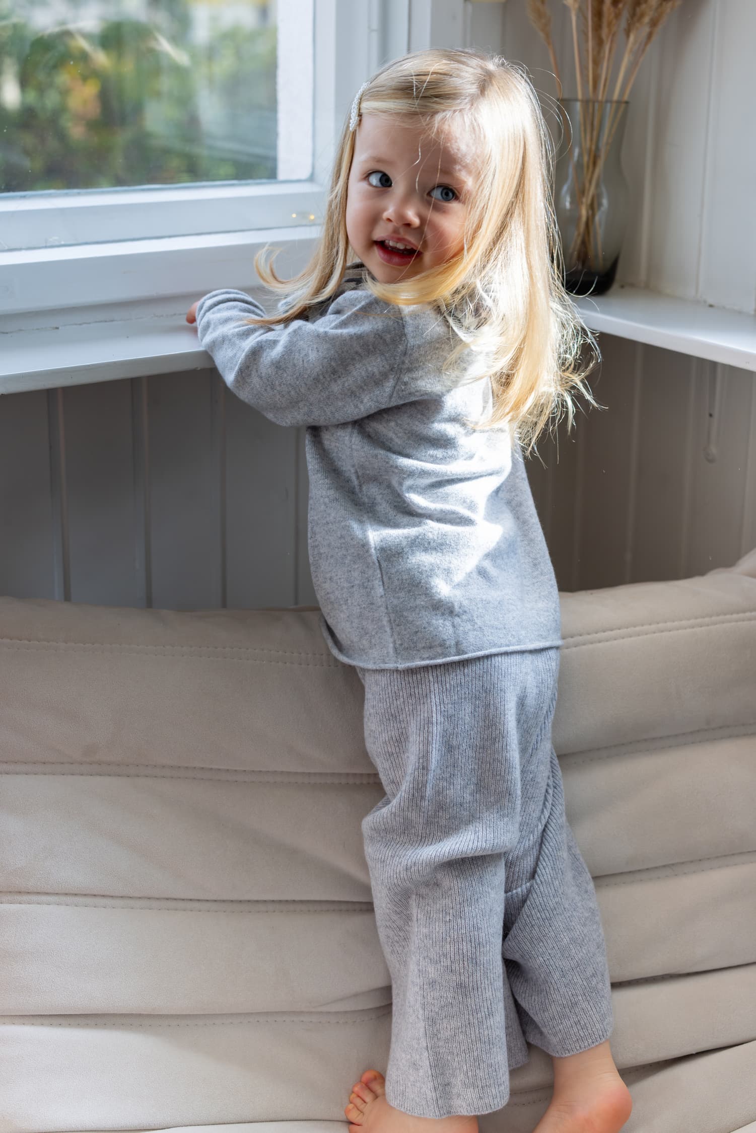 Mädchen in hellgrauem Kaschmiroutfit