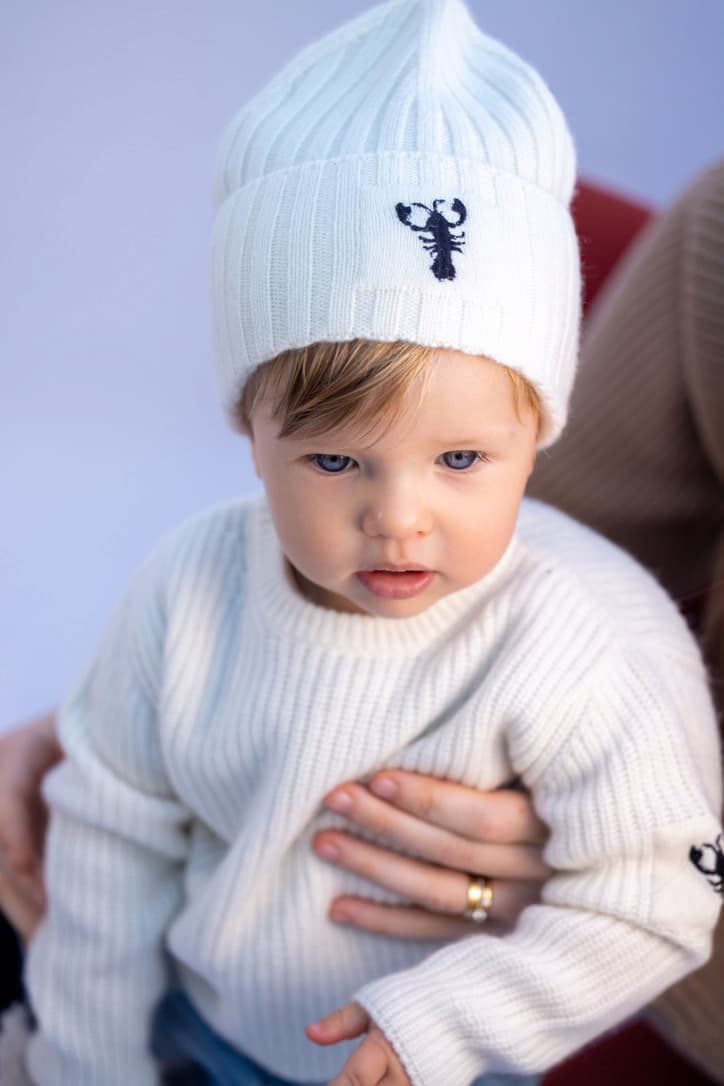 Porträt Junge mit weiter Kaschmirmütze mit Lobster-Emblem